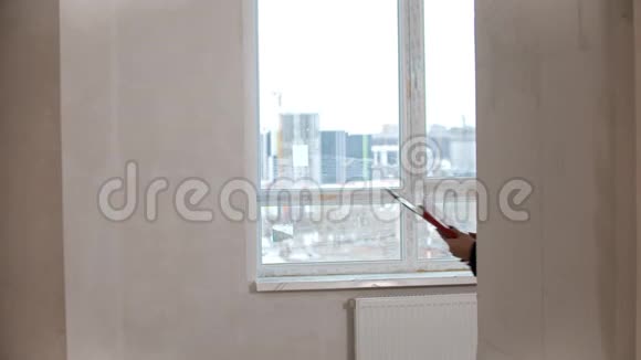 一位房地产经纪人向一家人展示了一套新的草稿公寓触摸墙壁和谈话视频的预览图