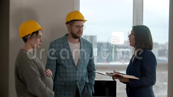 一个怀孕的女人和她的丈夫在新的公寓里看着一个男人在和房地产经纪人谈话视频的预览图