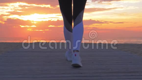 运动女子的特写镜头她的脚在沙滩上行走视频的预览图