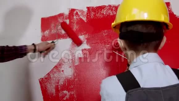 幸福的家庭修理公寓小男孩和他的父亲用红色画墙视频的预览图