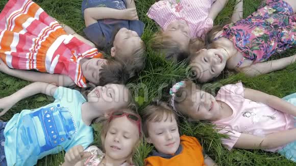春天公园里一群快乐的孩子躺在草地上视频的预览图