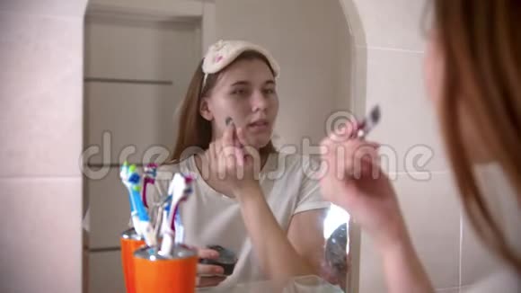 年轻女子用刷子在脸上敷面膜视频的预览图