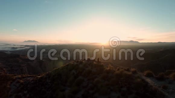 日落时分女人走在山脊上视频的预览图