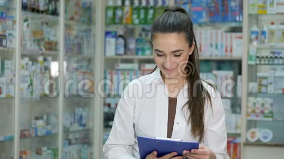 微笑的年轻药剂师摆姿势手里拿着一根羽毛笔视频的预览图