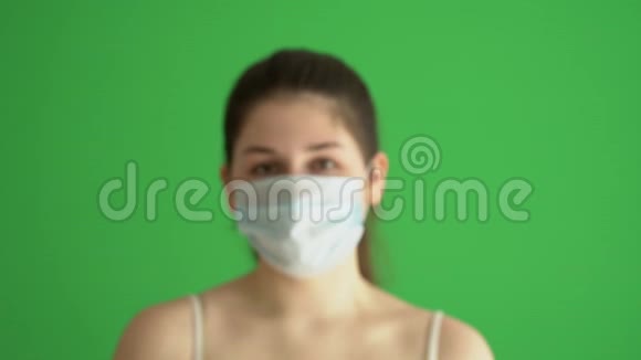 蒙面妇女保护自己免受流行病的侵袭年轻女性戴着绿色屏幕上的医疗面具特写照片视频的预览图