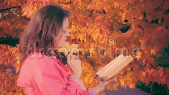 秋天的花园里有秋叶书的女人视频的预览图