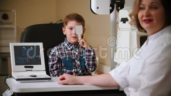 眼科诊所的治疗一个小男孩用眼罩遮住眼睛读信视频的预览图