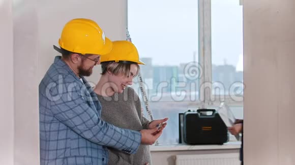 一位孕妇和她的丈夫看着新公寓的钥匙一位房地产经纪人跳着笑视频的预览图