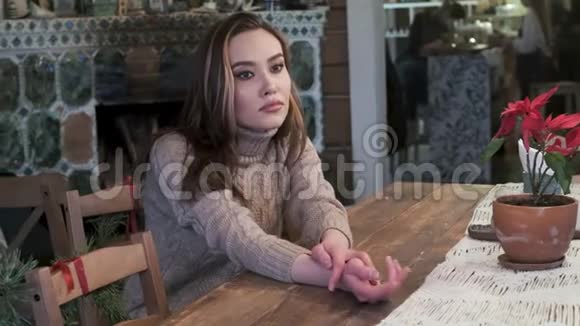 可爱的年轻亚洲漂亮女孩坐在舒适的咖啡馆里沉思视频的预览图