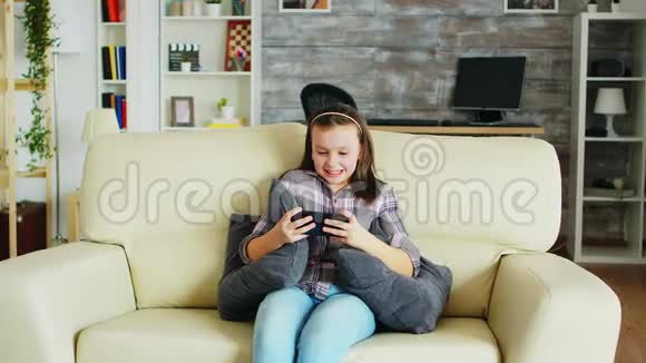 兴奋的小女孩在手机上玩电子游戏视频的预览图