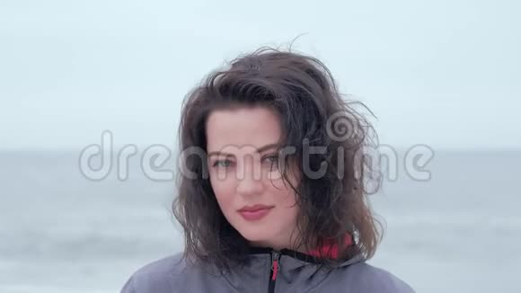 一个蓝眼睛女人在阴天海滩上的肖像视频的预览图
