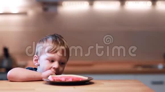 有趣的小男孩坐在厨房里试着把脚放在桌子上笑着快乐的男人快乐的尖叫视频的预览图