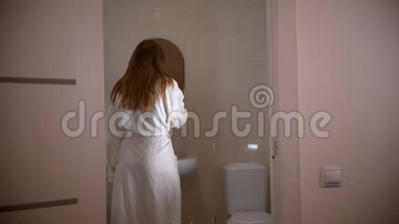 一个穿着浴衣的年轻妇女早晨刷牙视频的预览图