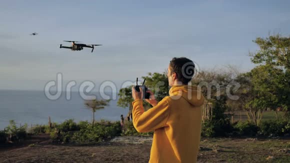 年轻的男飞行员乘坐直升机开始飞行旅游摄影师驾驶无人机飞过一个地方视频的预览图