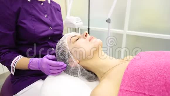 美容师在一家美容院诊所向一位年轻女子展示一种药物一种治疗药物视频的预览图