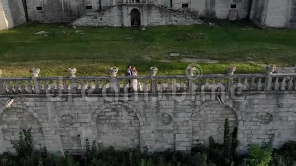 幸福的新婚夫妇站在美丽城堡的背景上互相看着对方亲吻着对方视频的预览图