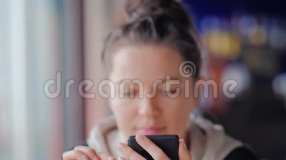 漂亮的蓝眼睛女人在咖啡馆里用手机发短信视频的预览图
