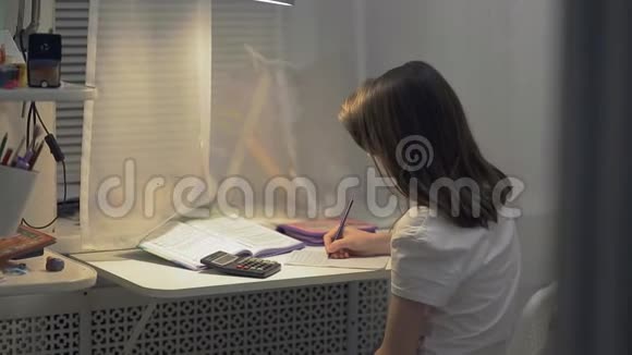 十几岁的女孩在房间里的一张桌子上做家庭作业在家上学视频的预览图