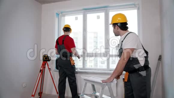 公寓维修一名工人测量房间的窗户并在公寓计划上做标记视频的预览图