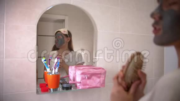 一位戴着面具的年轻女子在浴室的镜子前跳舞唱歌视频的预览图