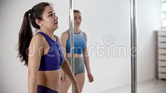 三个女人在白人工作室接受钢管舞训练视频的预览图