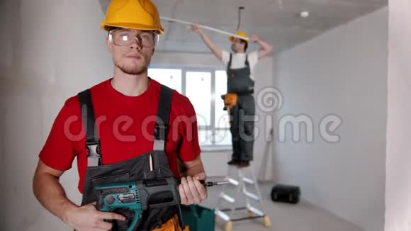 选秀室的公寓维修一名男子工人站在摄像机前把钻头递给另一名男子视频的预览图