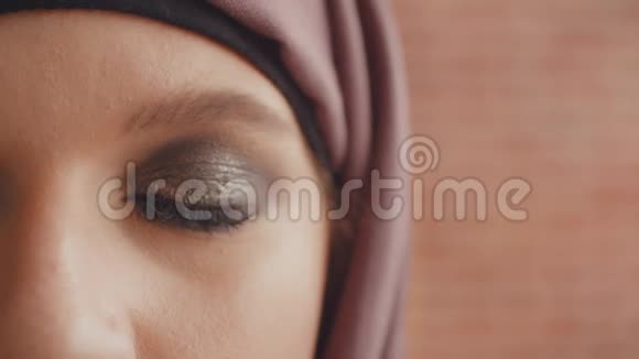 穆斯林妇女的开放眼睛闭上一只涂了漆的穆斯林眼睛慢慢睁开视频的预览图