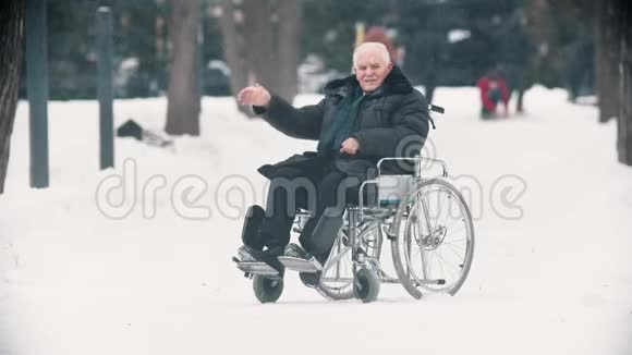 一位老兵坐在轮椅上用手向摄像机挥手视频的预览图