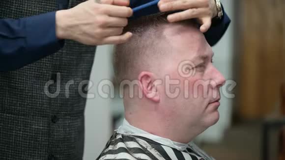 男人理发店理发一位剪头发金发的男士的贴身剪裁视频的预览图