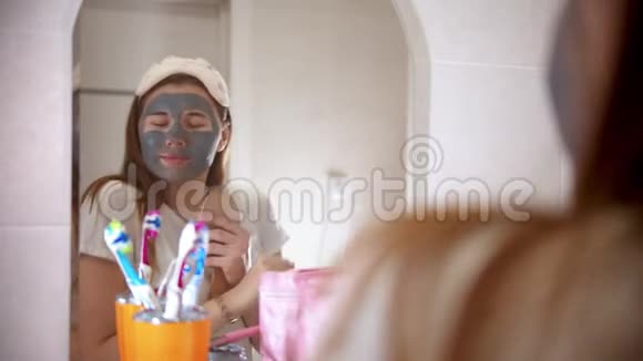 一个年轻漂亮的女人脸上戴着面具在浴室的镜子前跳舞唱歌视频的预览图