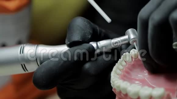 一个牙医的特写练习用钻床模拟牙齿骨架牙医巧妙地练习视频的预览图