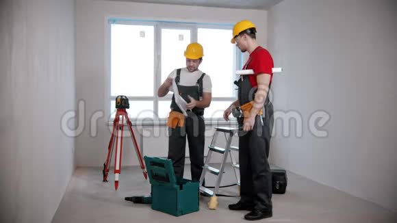 公寓维修两名男性工人打开一个公寓计划并查看它视频的预览图