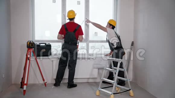 房间里的公寓维修两名工人测量窗户视频的预览图