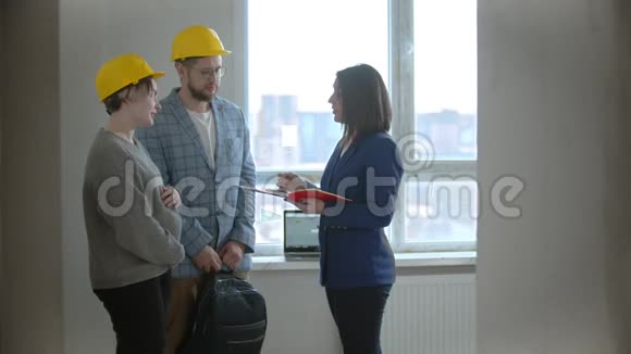 一名孕妇和丈夫在一栋新楼的公寓里和一名房地产经纪人谈话视频的预览图