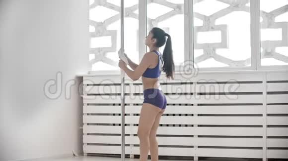 女子钢管舞培训师用抹布清洗杆子视频的预览图