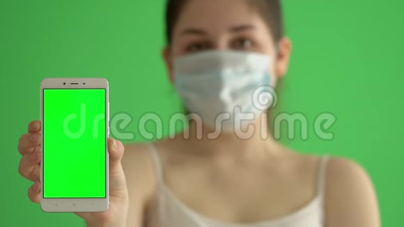 蒙面妇女保护自己免受流行病的侵袭年轻女性戴着绿色屏幕上的医疗面具一个女人抱着她视频的预览图