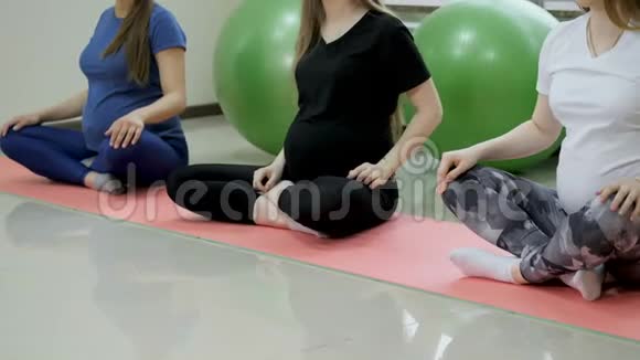 一群快乐的孕妇在健身房锻炼瑜伽和冥想莲花姿势视频的预览图