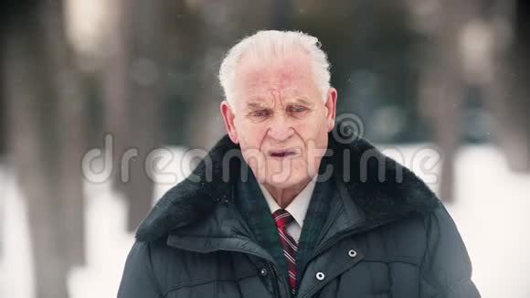 一位老人站在户外下雪视频的预览图