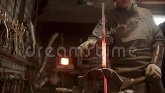 一个铁匠在夹子里锻造一块扭曲的金属视频的预览图