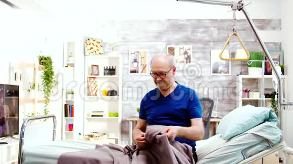 护士帮助一位残疾退休老人从病床上站起来视频的预览图