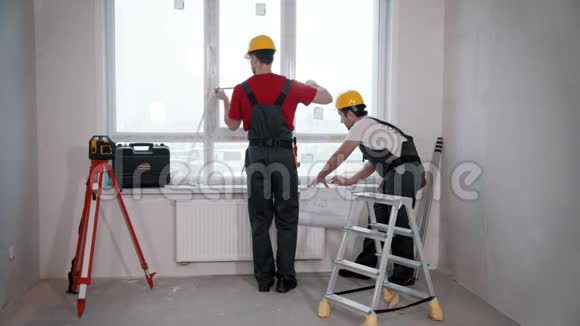 公寓维修工人测量房间窗户视频的预览图