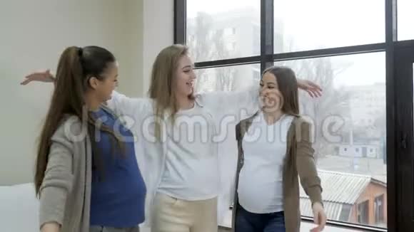 产前课堂上快乐的孕妇站在窗外的背景旁视频的预览图