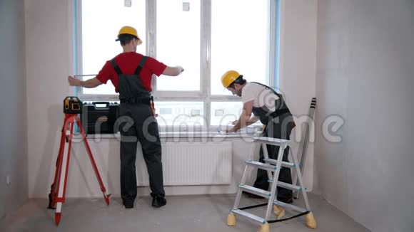 房间里的公寓维修工人测量窗户视频的预览图