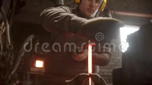 一个铁匠把铁的细节放在夹子之间旋转视频的预览图