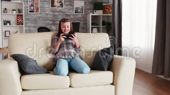 开朗的小女孩玩电子游戏视频的预览图