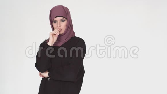 一个戴着头巾的体贴的女孩抬起她的手指有一个想法穆斯林妇女站着思考然后抚养她视频的预览图