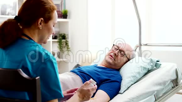 养老院护士给躺在病床上的病人开处方药视频的预览图