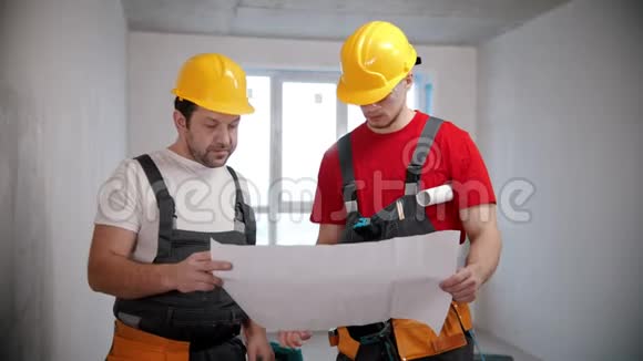 公寓维修两名工人在工作前讨论公寓计划并指着墙壁视频的预览图