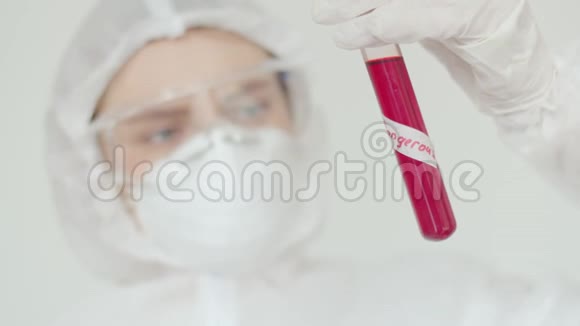 一位年轻的女科学家检查一个带有生物危险的红色物质的试管戴防护眼镜的女孩视频的预览图