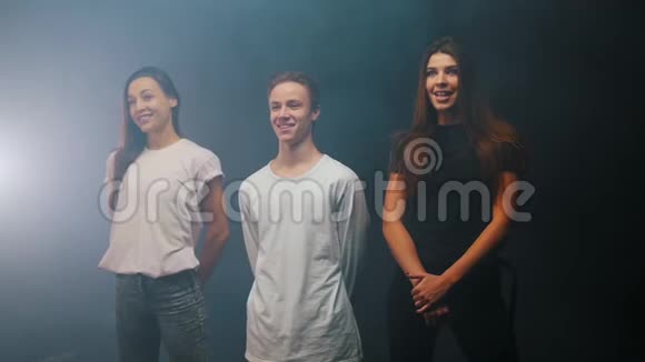 三个微笑的人站在演播室里的舞蹈团视频的预览图